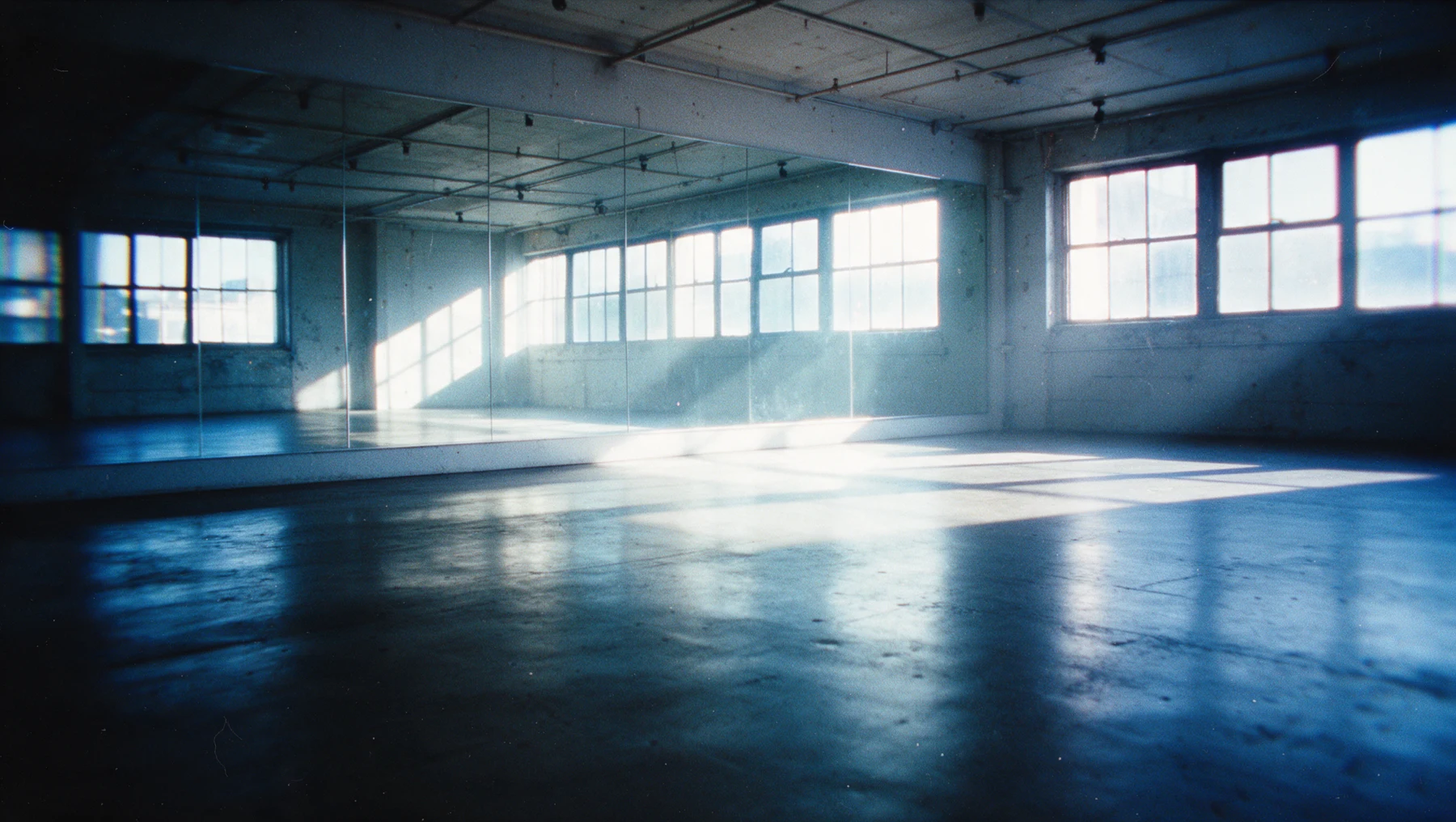 Blue-lit mirrored movement studio